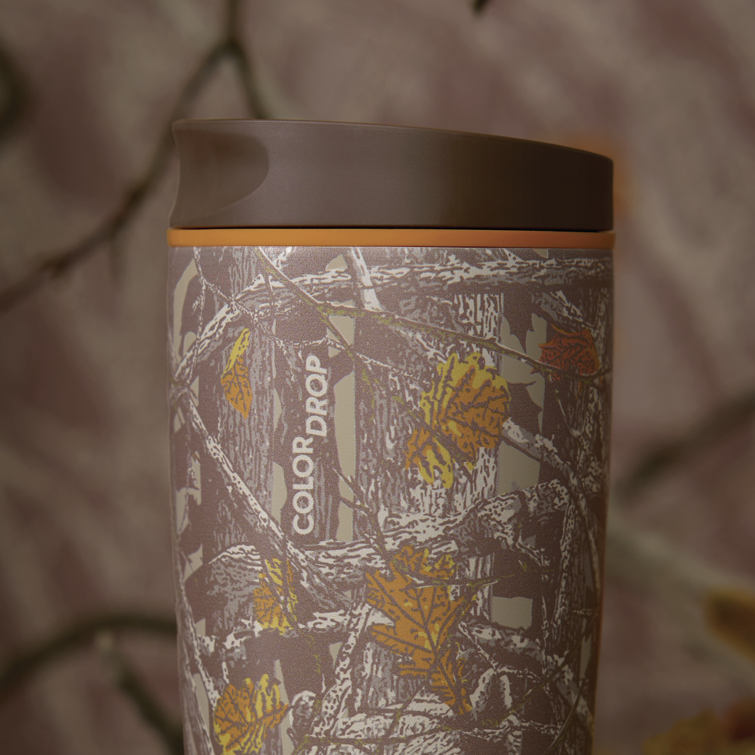 Owala FreeSip Sway in Out of Sight, woodland camo patterned body with orange lid accent ring and brown flip cap, COLOR DROP text visible on body